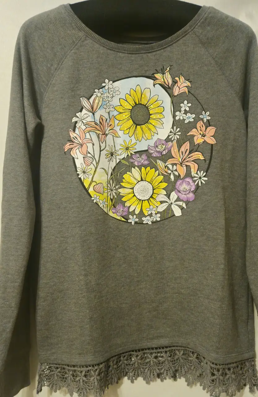 Buzo de cuello redondo gris con estampado de yin yang floral. Detalles de encaje en el borde inferior. Ideal para un look casual y cómodo.