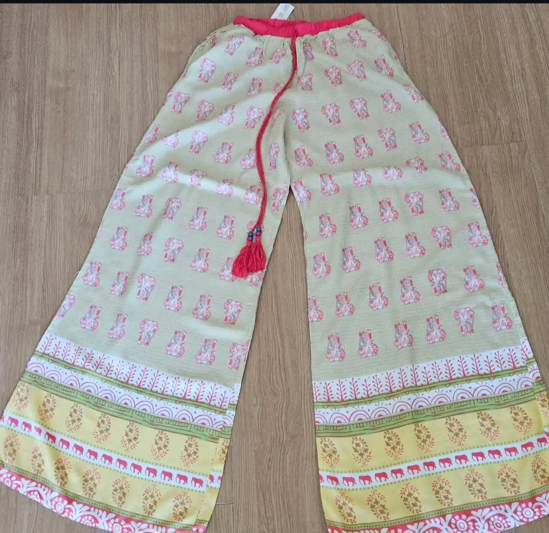 Pantalón palazzo de tela liviana, con estampado de elefantes en tonos pastel y detalles en amarillo y rosa. Ideal para un look boho chic y fresco.
