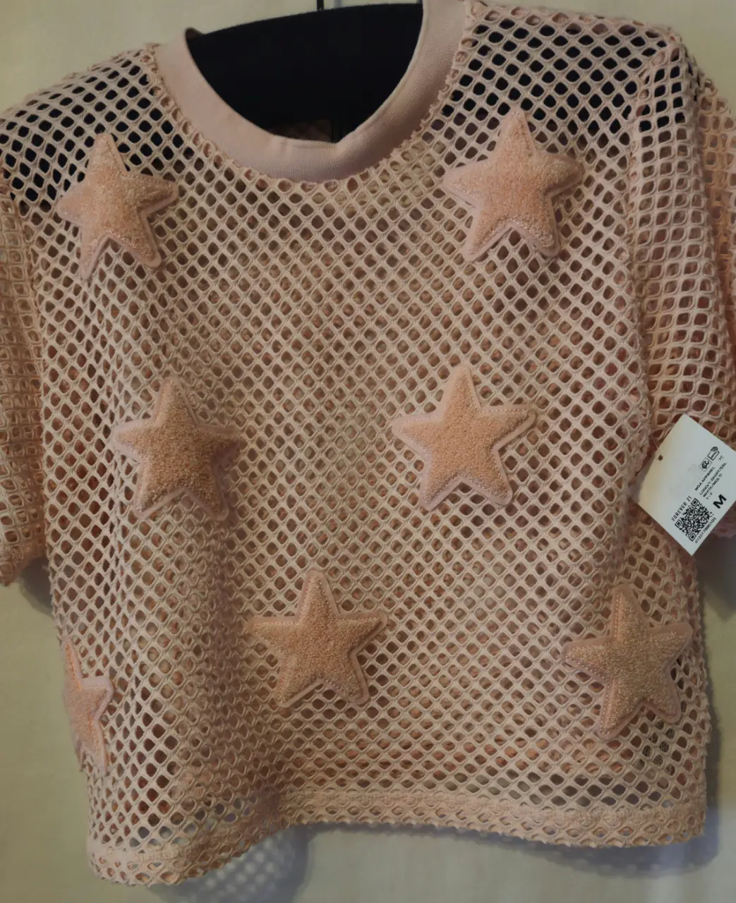 Remera de red rosa con estrellas en relieve. Ideal para un look moderno y audaz.