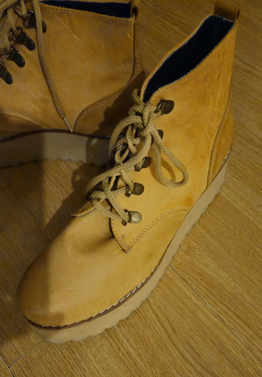 Botines amarillos de cuero con cordones y suela gruesa. Ideales para un look casual y moderno.