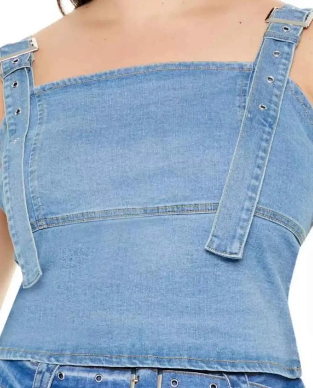 Top de jean con tiras ajustables y hebillas. Diseño con costuras marcadas y cierre en la espalda. Ideal para un look casual y moderno.
