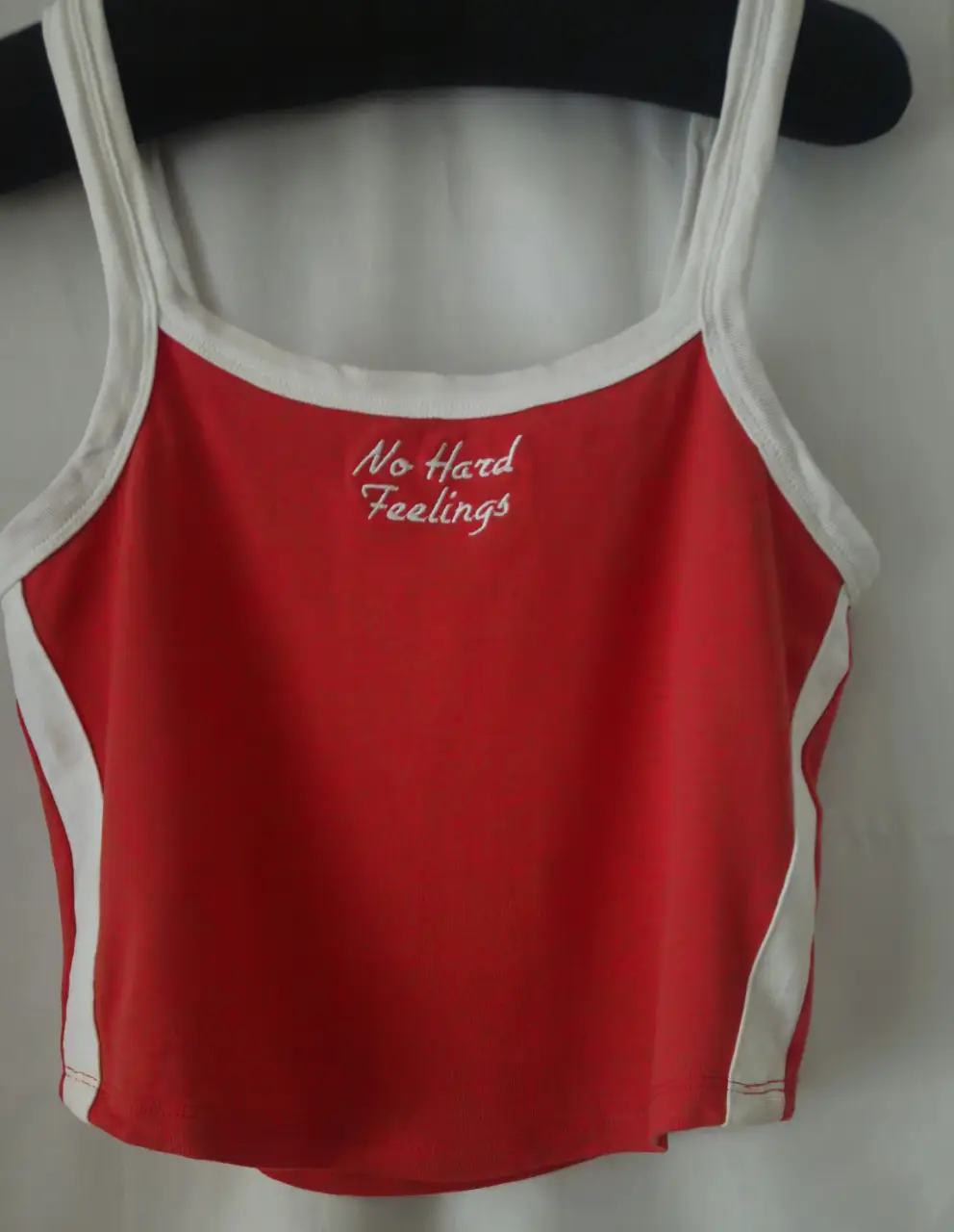 Musculosa roja con detalles blancos y la frase "No Hard Feelings" bordada. Ideal para un look casual y cómodo.