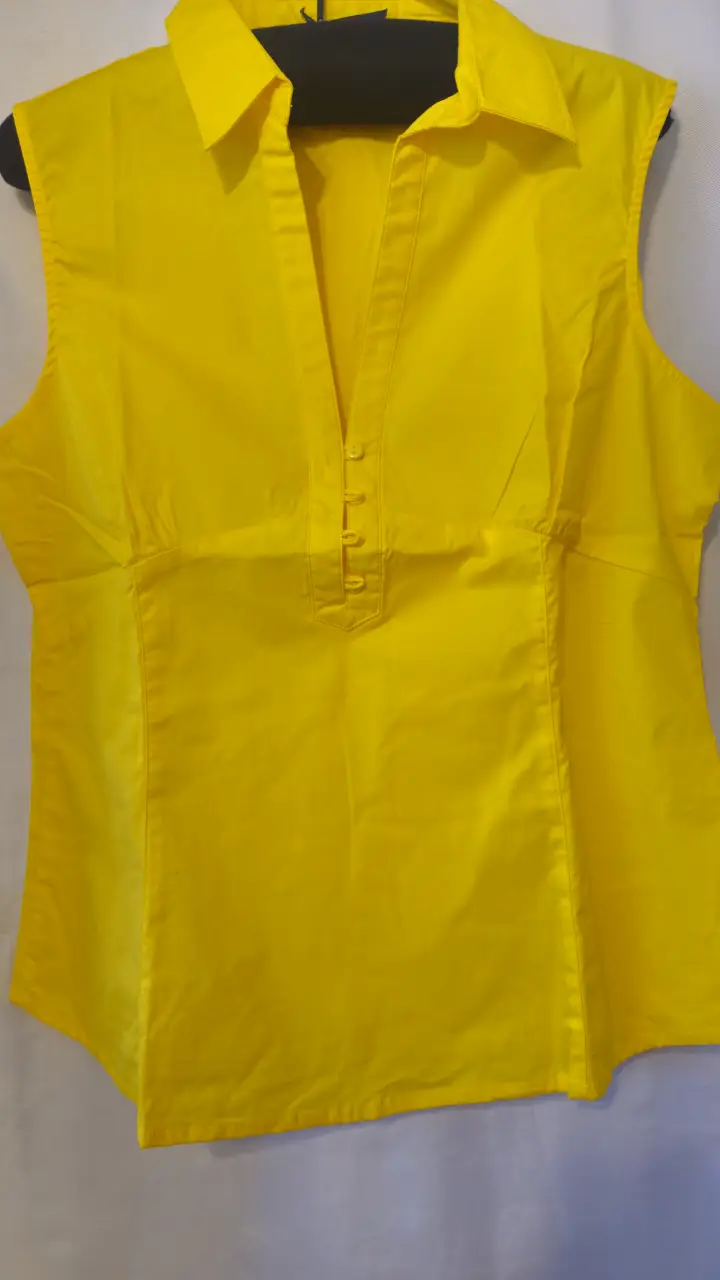 Blusa amarilla sin mangas con cuello camisero y botones. Ideal para un look fresco y elegante.