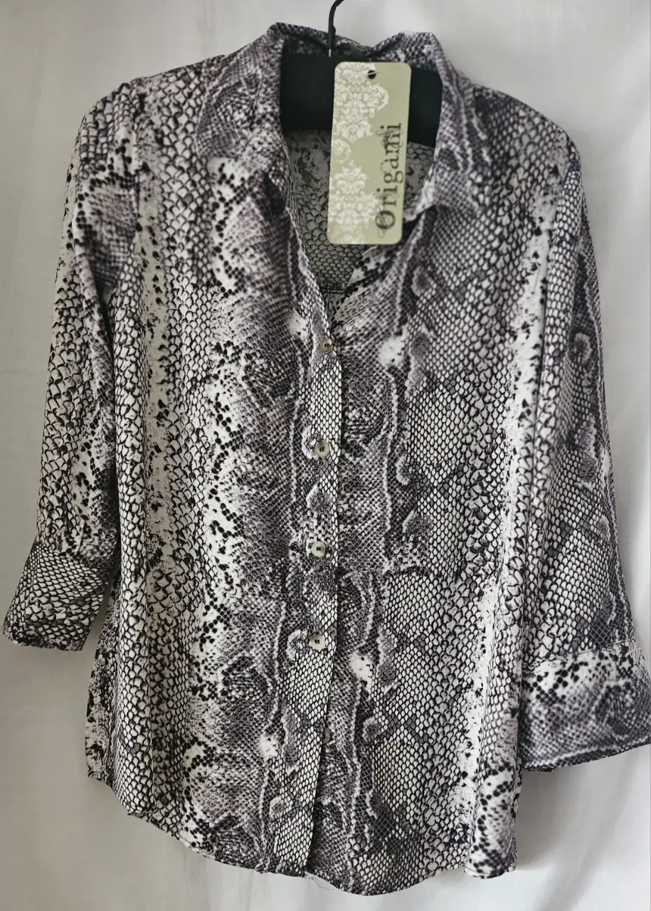 Camisa estampada con diseño de serpiente, manga 3/4 y cuello clásico. Ideal para un look casual y moderno.
