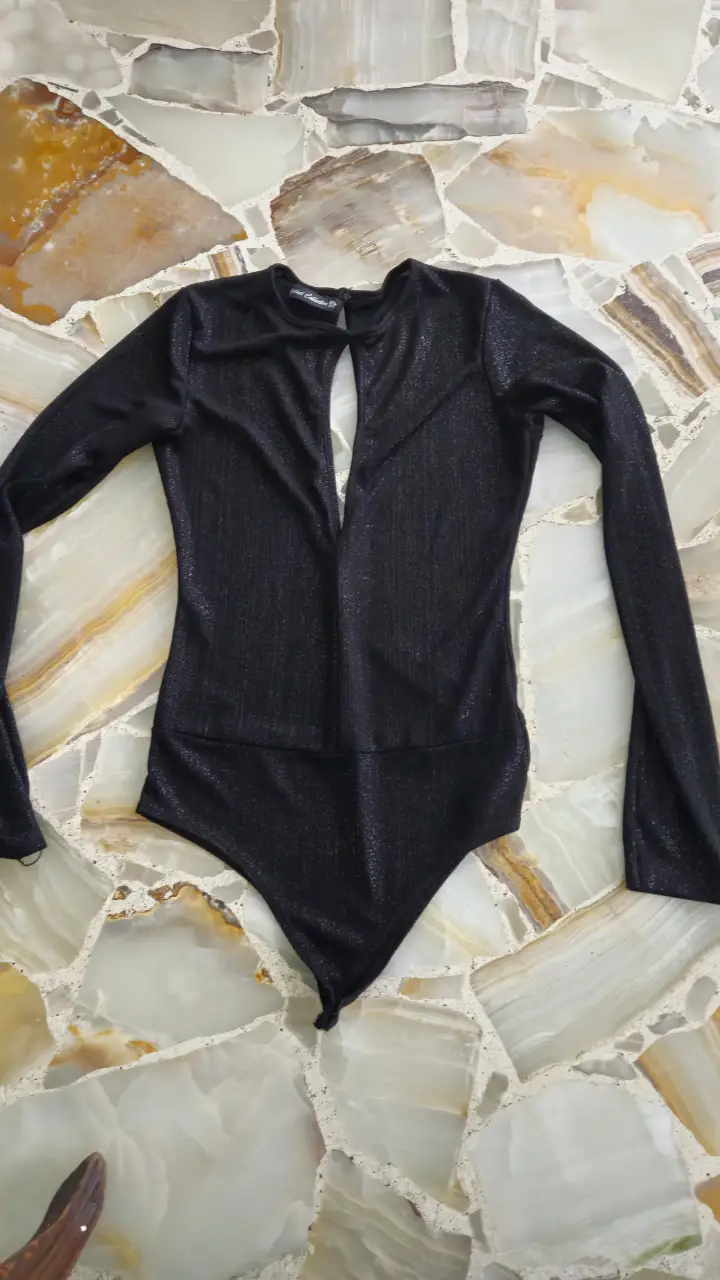 Body negro con brillos, manga larga y escote pronunciado. Ideal para fiestas y eventos.