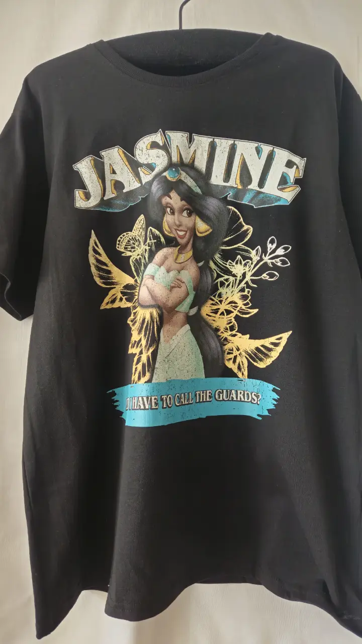 Remera negra de algodón con estampado de la princesa Jasmine de Disney. Diseño con la frase "Do I have to call the guards?". Ideal para fans de Disney y un look casual.