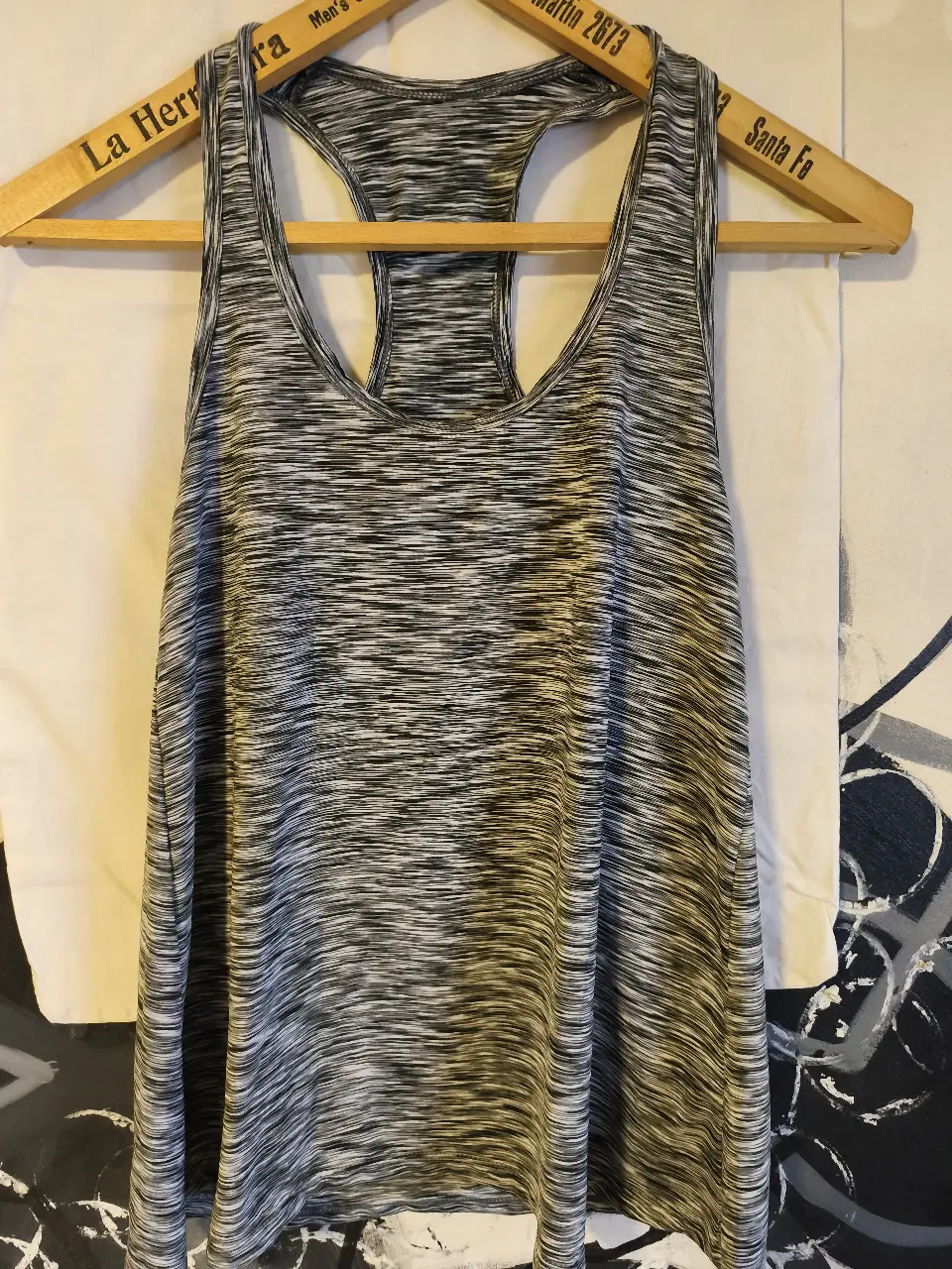 Musculosa deportiva para mujer, con diseño jaspeado en tonos grises y blancos. Ideal para entrenamientos y actividades físicas. Confeccionada en tejido ligero y transpirable.