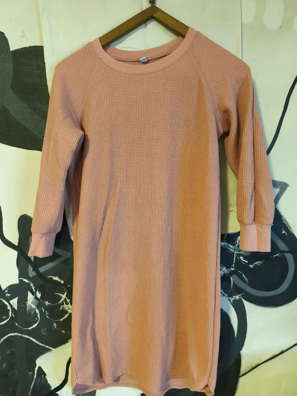 Vestido midi de tejido waffle en color rosa, ideal para un look casual y cómodo. Manga larga con puños y cuello redondo.