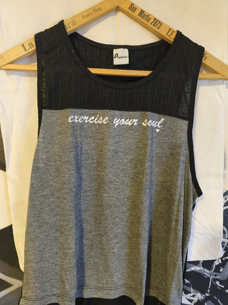 Musculosa deportiva para mujer, con frente gris y detalle "exercise your soul" en blanco. La parte superior es de color negro con diseño calado. Ideal para entrenamientos.