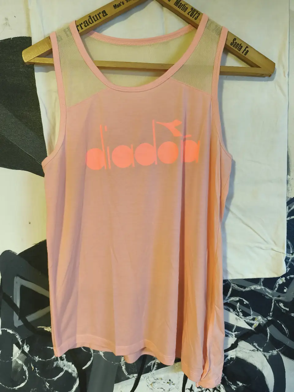 Musculosa deportiva Diadora rosa con detalles en color coral. Ideal para entrenamientos y actividades físicas. Diseño cómodo y transpirable.