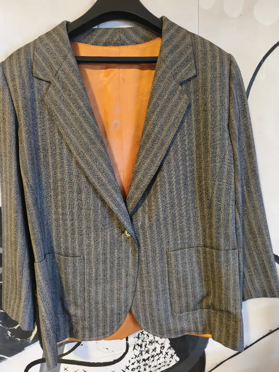 Elegante blazer baige a rayas con forro naranja. Ideal para un look formal o de trabajo con un toque vintage.