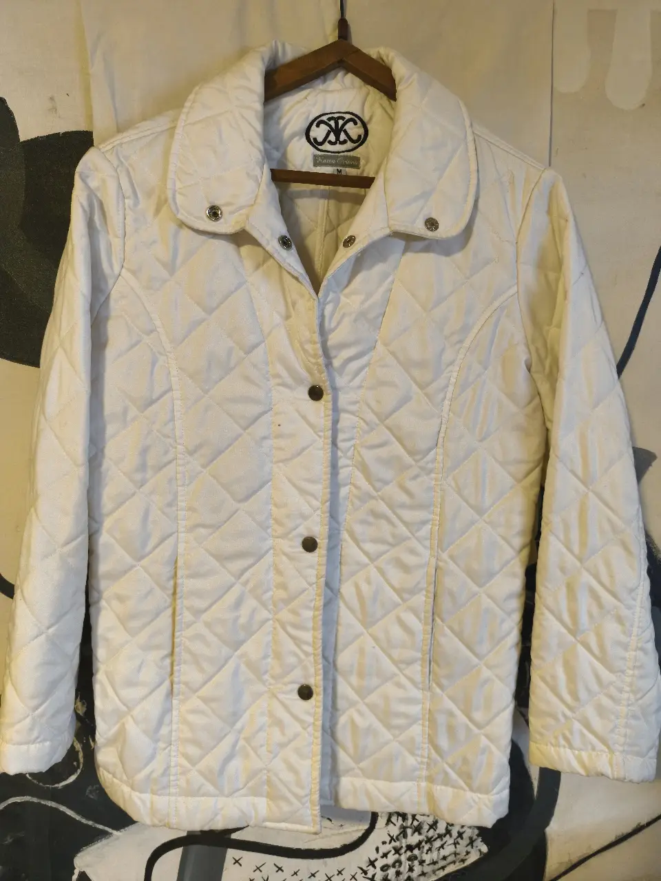 Campera acolchada blanca para mujer, ideal para el invierno. Diseño clásico con cuello camisero y cierre con botones. Perfecta para un look casual y abrigado.