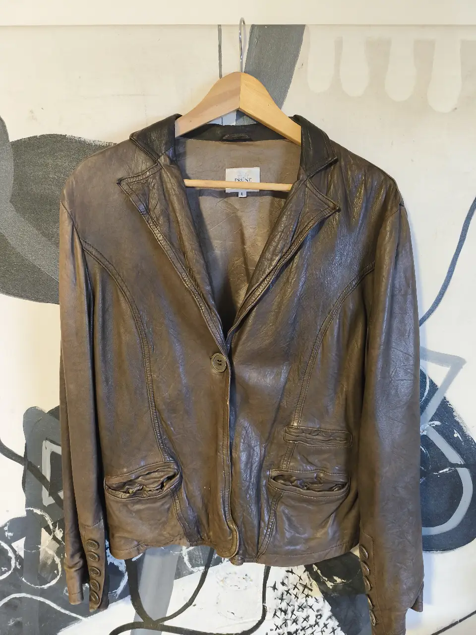 Chaqueta de cuero marrón con diseño de blazer, ideal para un look elegante y a la vez canchero. Posee dos bolsillos frontales y un botón para cerrar. Perfecta para usar en cualquier ocasión.