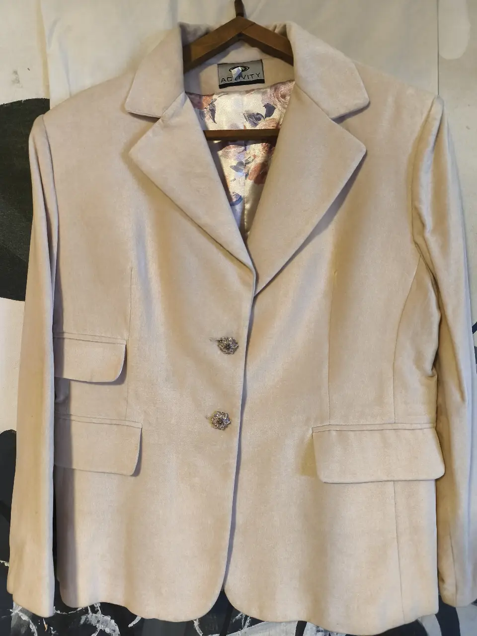 Elegante blazer de mujer en tono crudo, ideal para un look formal o de trabajo. Confeccionado en un tejido similar a la gamuza, presenta dos bolsillos delanteros y botones decorativos. Un clásico atemporal para tu guardarropa.