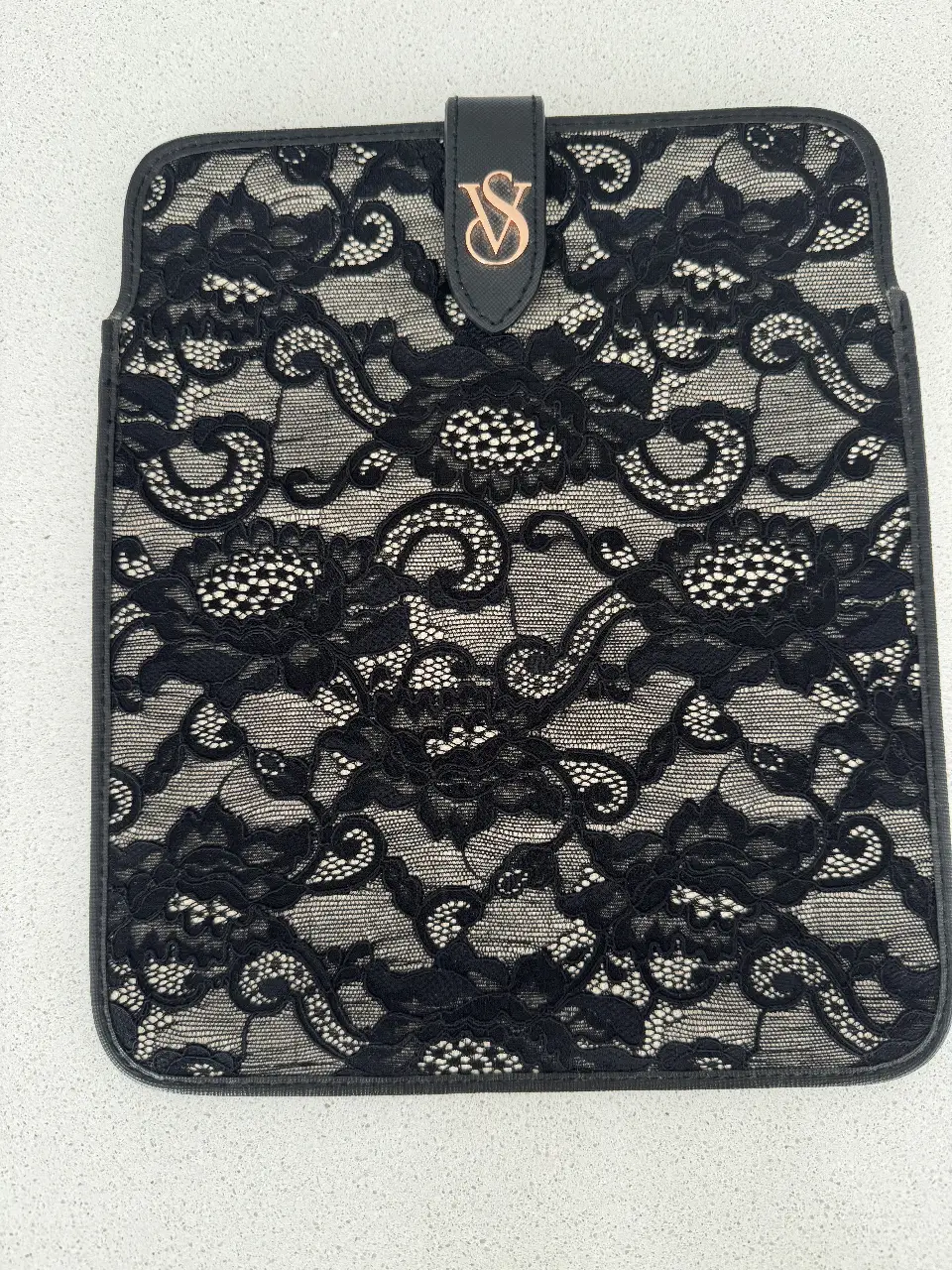 Funda para tablet negra con encaje y logo de Victoria's Secret. Ideal para proteger tu dispositivo con estilo y elegancia.