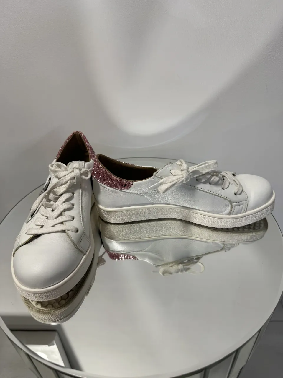 Zapatillas Paruolo blancas de cuero con detalles de glitter rosa en el talón y una estrella gris con estampado de serpiente en el lateral. Cordones blancos. 