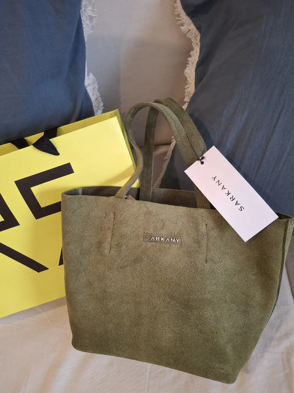 Cartera tote bag de gamuza verde, con etiqueta de la marca Sarkany. Ideal para llevar tus esenciales con estilo.