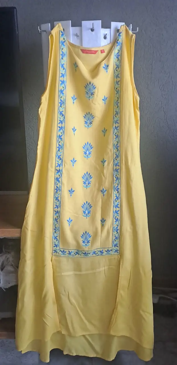 Vestido indu largo amarillo con detalles bordados en azul. Diseño sin mangas, ideal para un look fresco y elegante. Perfecto para eventos casuales o salidas de verano.