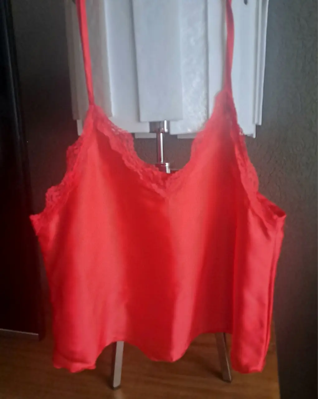Top de satén rojo con detalles de encaje en el escote. Ideal para una salida o fiesta.