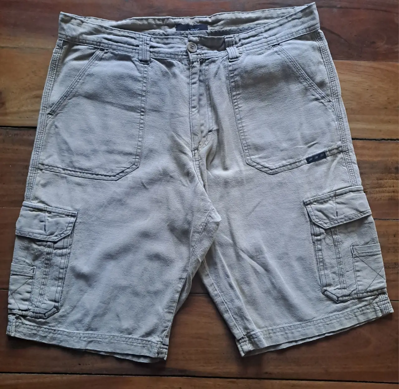 Beemuda de hombre tipo cargo en color beige, con múltiples bolsillos y un diseño utilitario. Ideal para un look casual y cómodo.