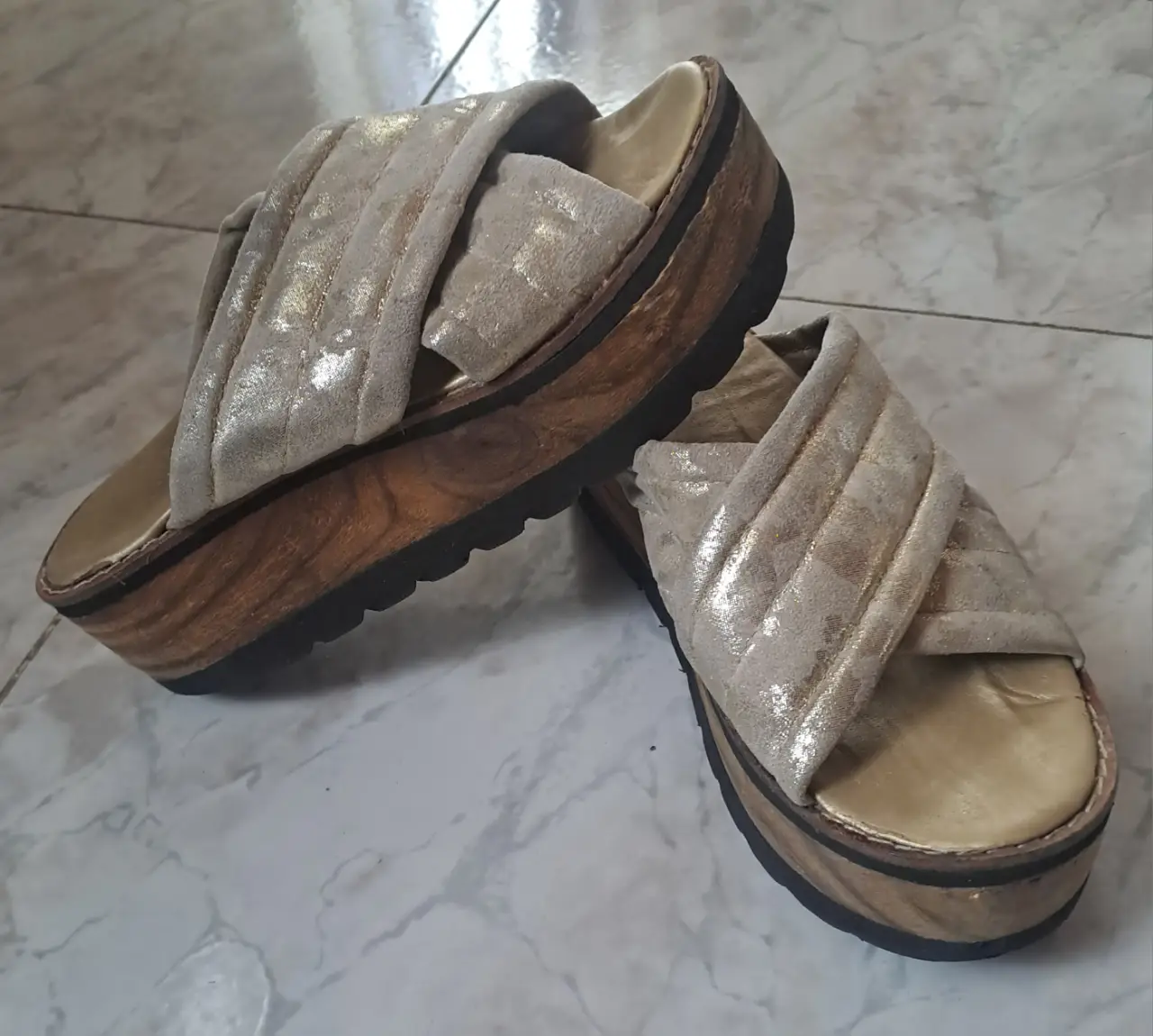 Sandalias suecos de plataforma color crudo y doradao con diseño cruzado en la parte superior. Ideales para un look casual y cómodo.