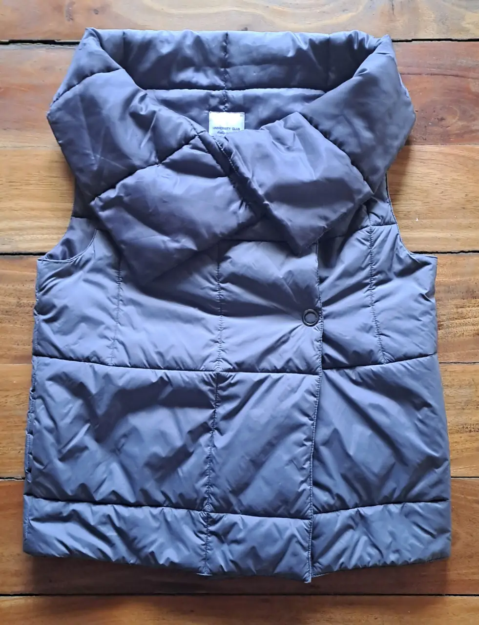 Chaleco gris acolchado con cuello alto. Ideal para el invierno, con un diseño moderno y abrigado. Perfecto para un look casual y cómodo.