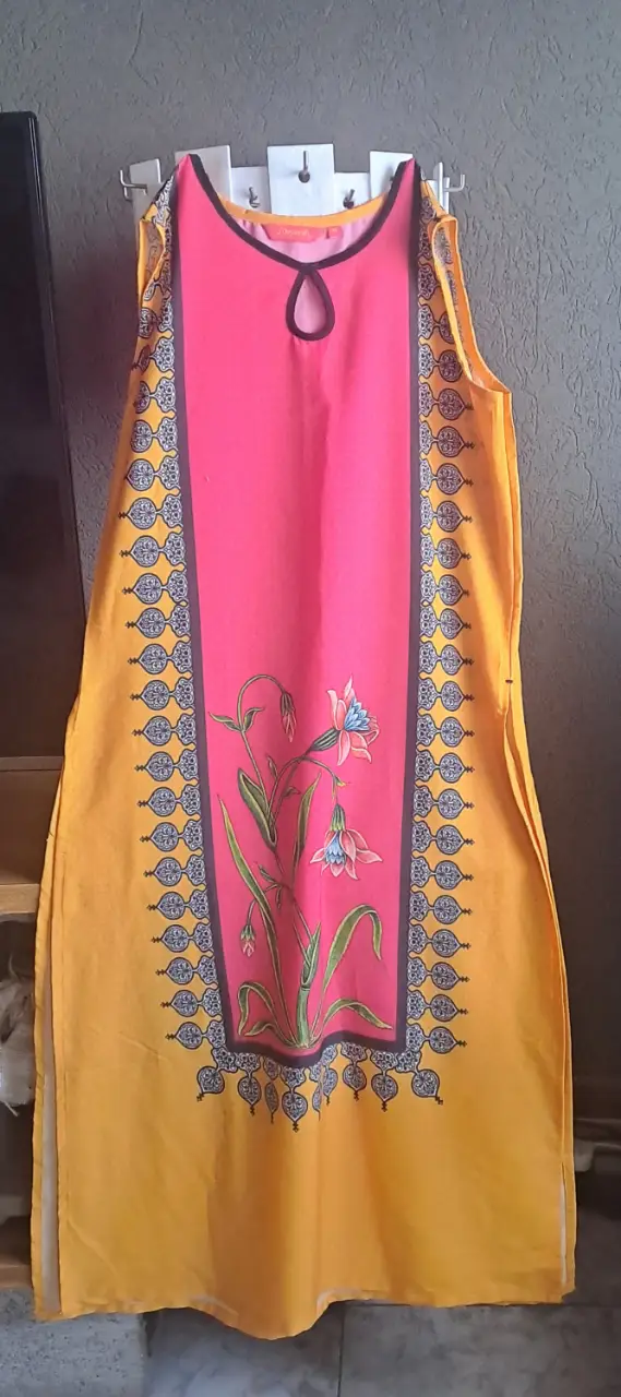 Vestido indu sin mangas, con estampado floral en la parte delantera. Diseño con cuello redondo y detalle de abertura. Ideal para un look fresco y femenino.