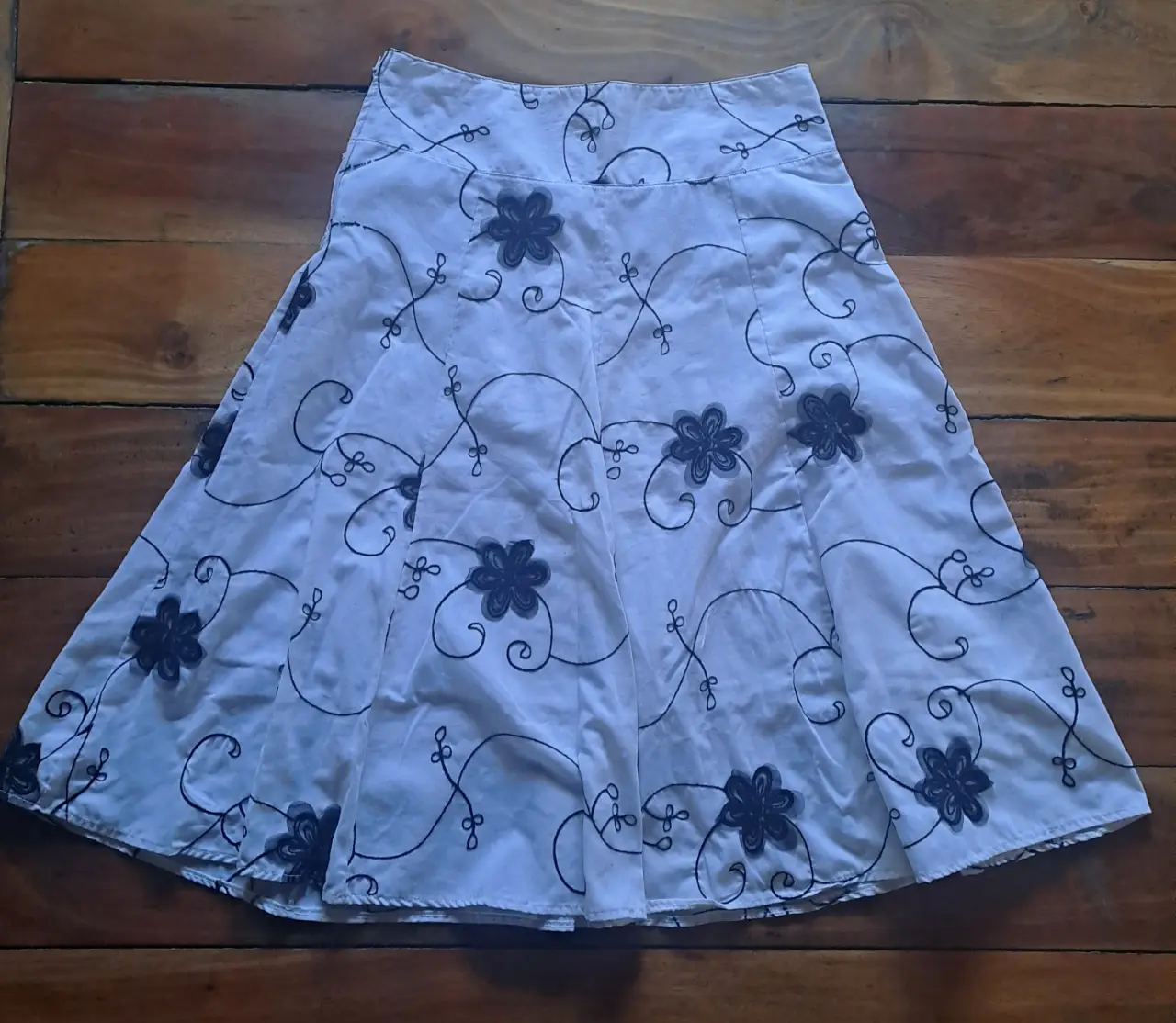 Pollera larga blanca con estampado bordado floral en negro. Ideal para un look casual y fresco.