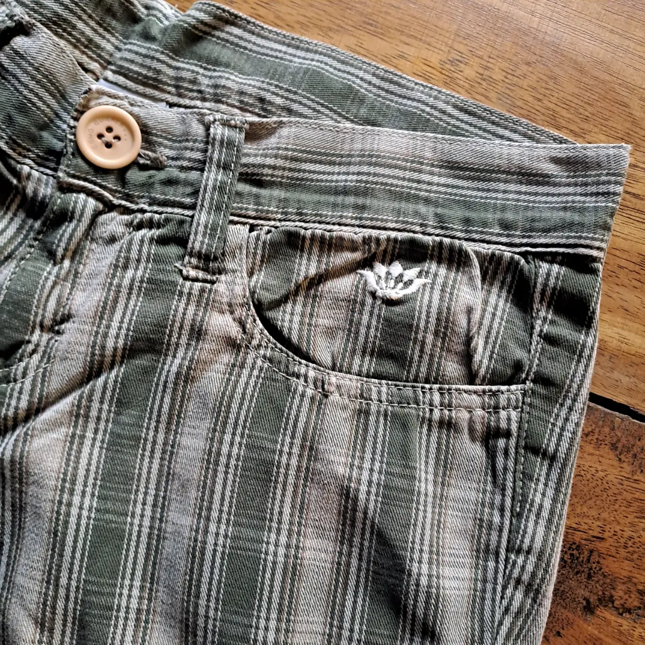 Pantalón babucha de niña,  con estampado a rayas en tonos verdes claros y beige. Tiene bolsillos delanteros y puños en los tobillos. La marca es Como Quieres.