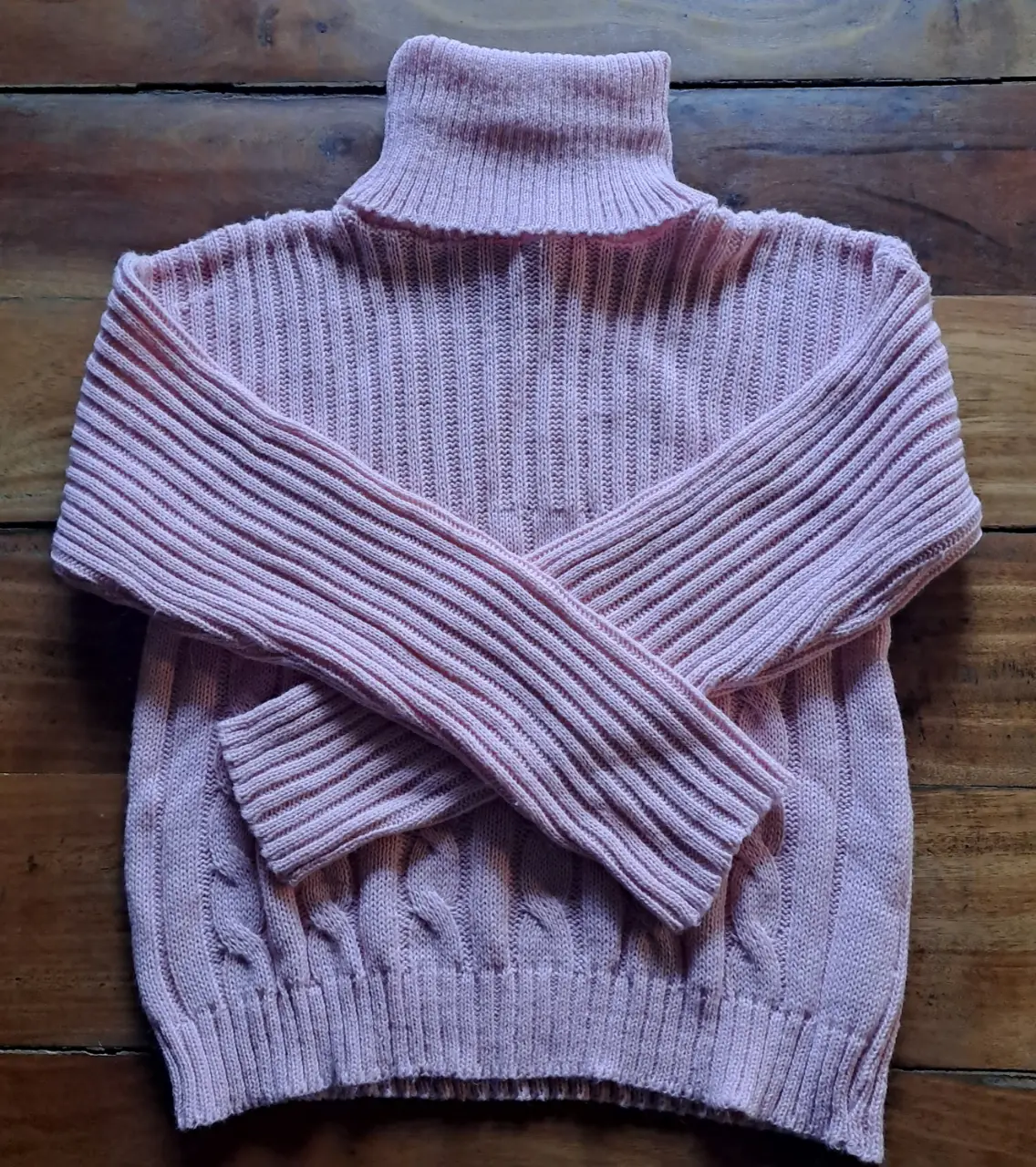 Sweater de cuello alto en color rosa, tejido con diseño de trenzas en la parte inferior y canalé en el cuerpo y mangas. Ideal para un look casual y abrigado.