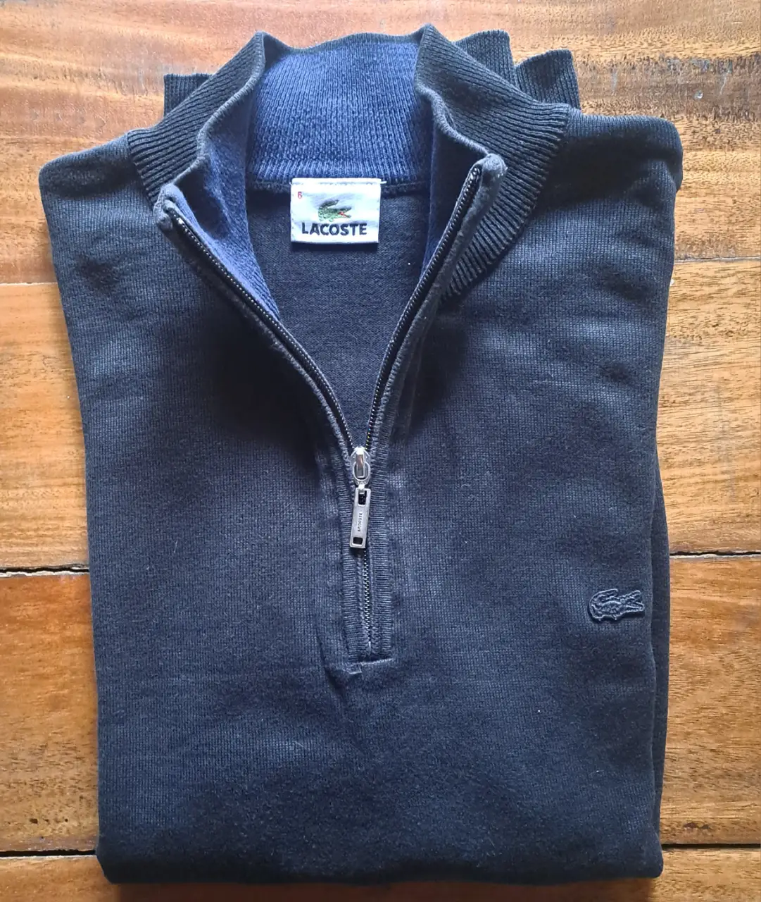 Sweater Lacoste negro con cierre y cuello polera. Ideal para un look casual y abrigado.