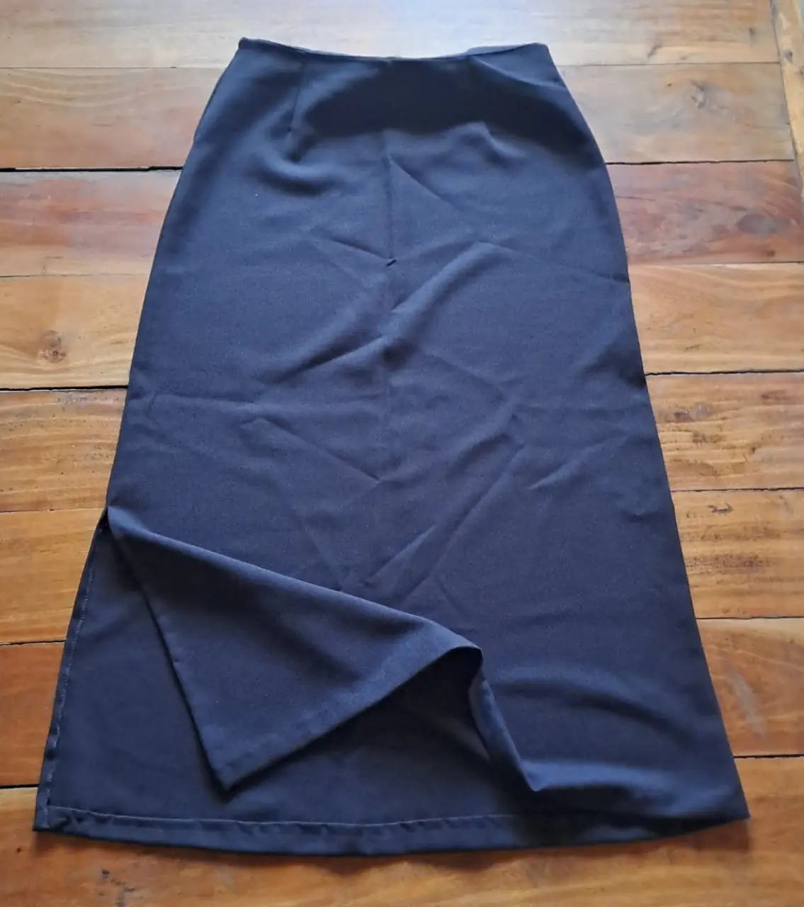 Pollera sastrera negra talle 4. Ideal para un look formal o de trabajo. Diseño clásico y elegante. Cuenta con un tajo lateral que le da un toque moderno.