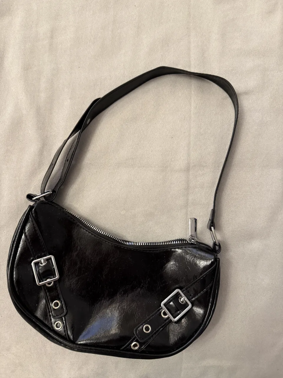 Cartera negra estilo Y2K, con hebillas y detalles metálicos. Perfecta para darle un toque rocker a tu outfit.