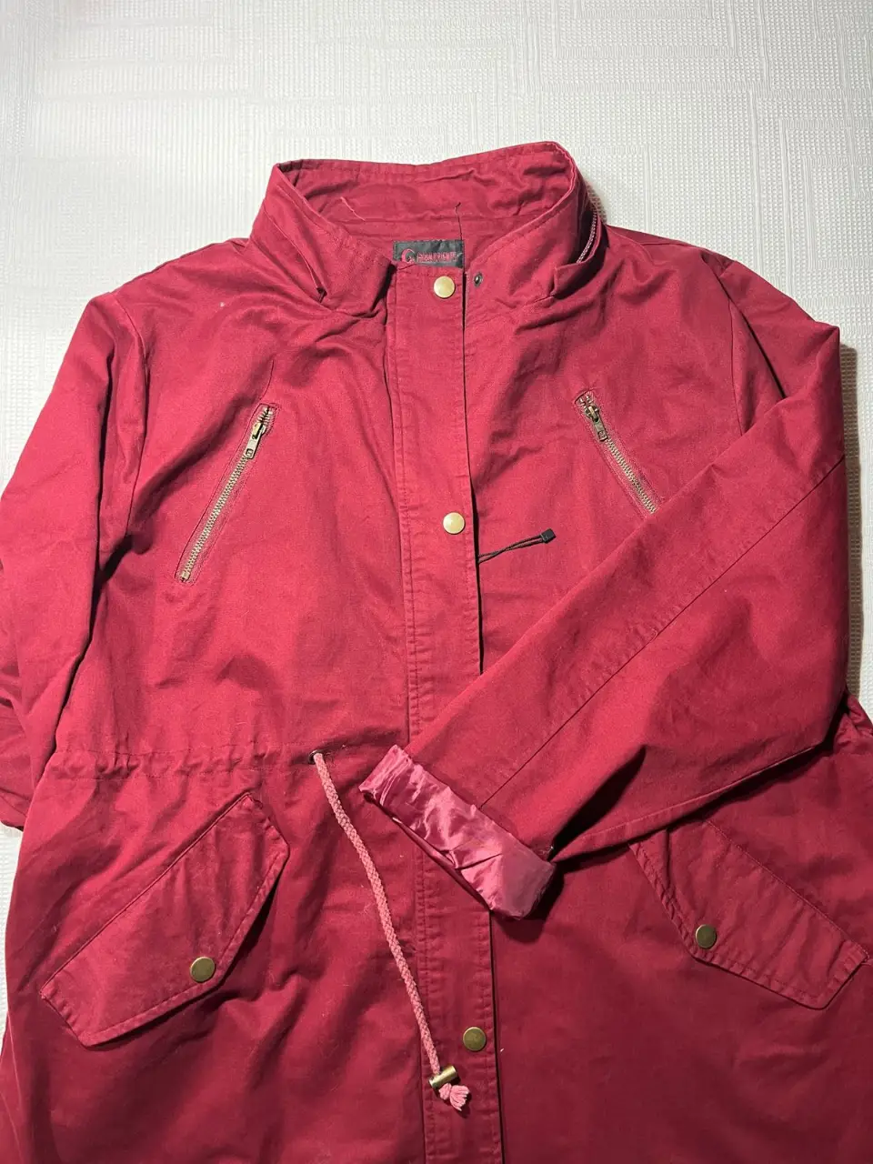 Campera roja de mujer, estilo deportivo. Posee cierre y bolsillos con botones dorados. Ideal para un look casual y abrigado.