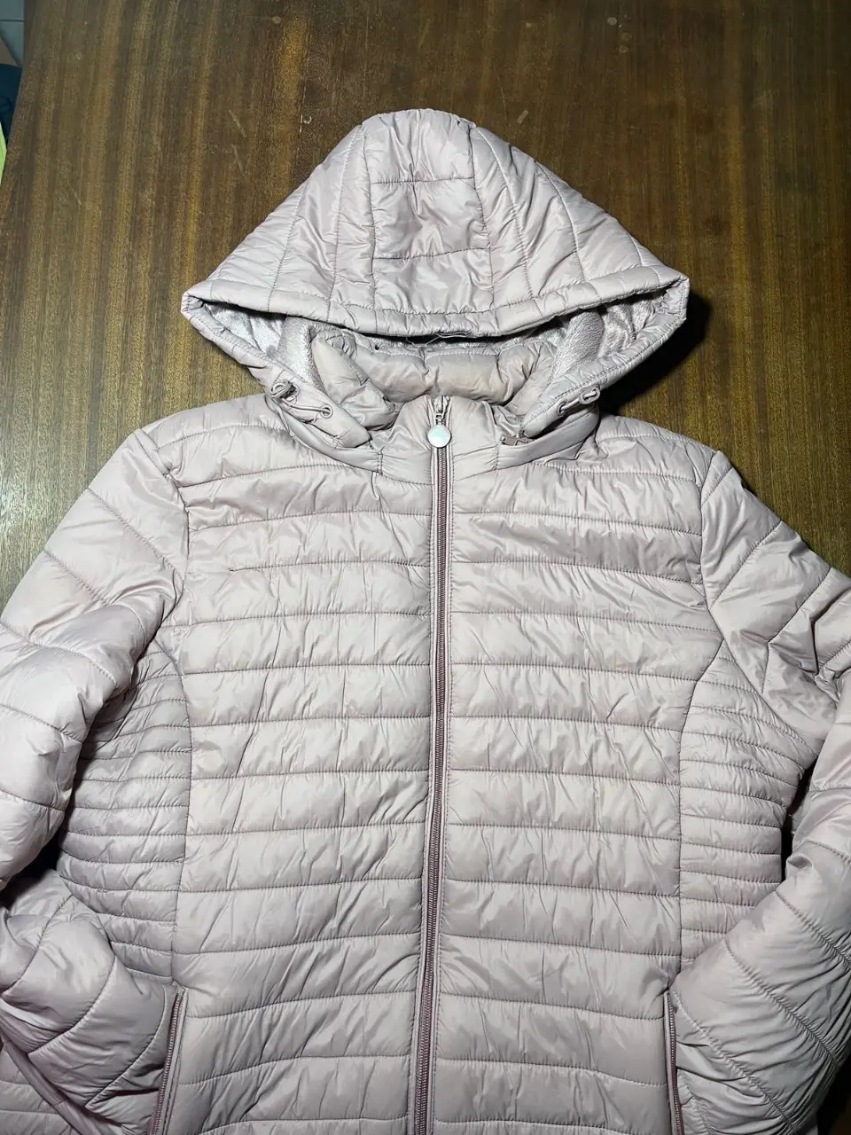 Campera acolchada rosa con capucha, ideal para el invierno. Posee cierre y bolsillos. Perfecta para un look casual y abrigado.