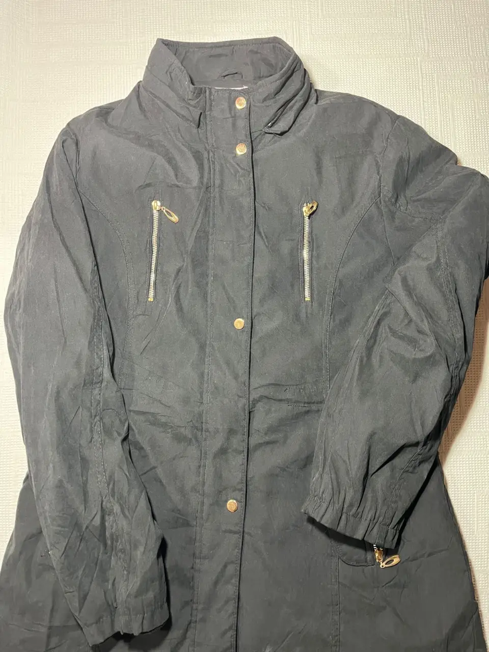 Campera negra de abrigo, con cierre y bolsillos con detalles dorados. Ideal para el invierno.