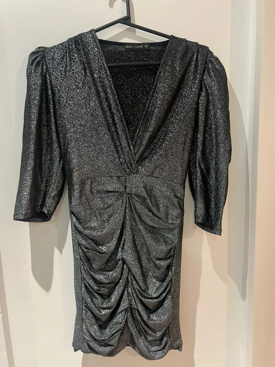 Vestido mini de fiesta con brillo, fruncido en la cintura y mangas 3/4. Ideal para eventos especiales y salidas nocturnas. Marca Heidi Clair.
