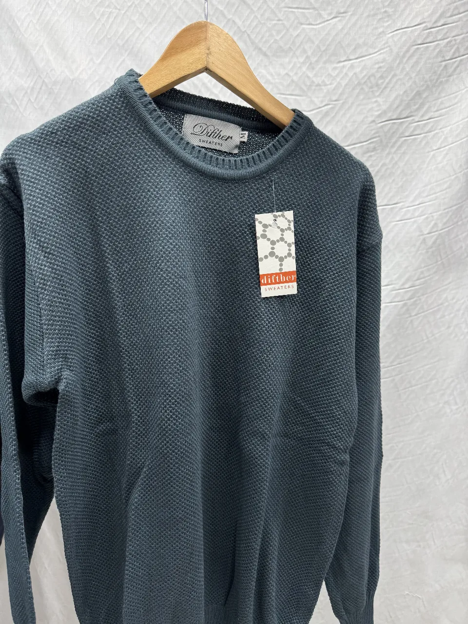 Sweater de hombre de punto grueso en color azul. Cuello redondo y etiqueta de la marca. Ideal para un look casual y abrigado.
