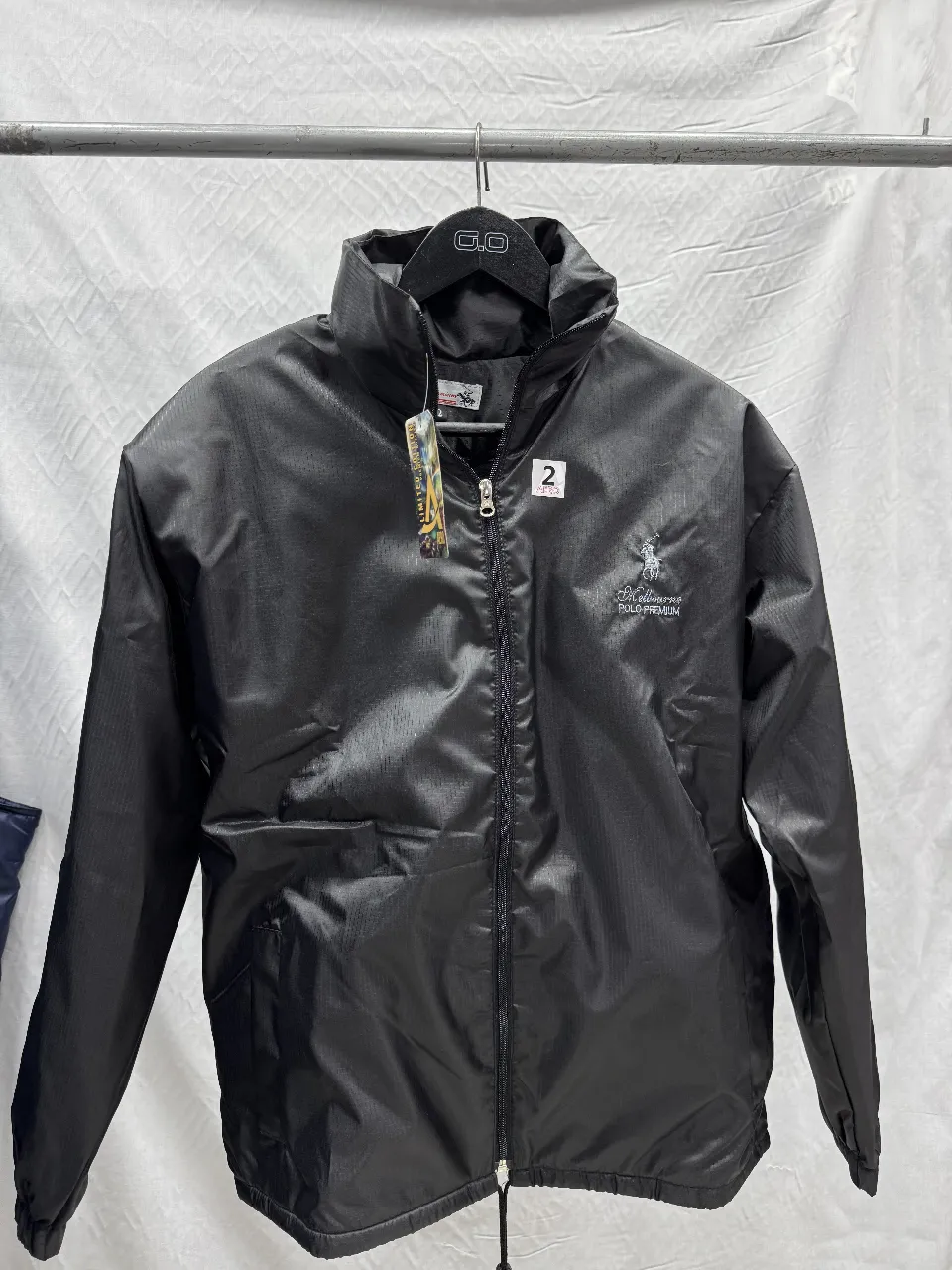 Campera rompevientos negra Melbourne Polo Premium, con cierre y cuello alto. Ideal para actividades al aire libre o uso casual.
