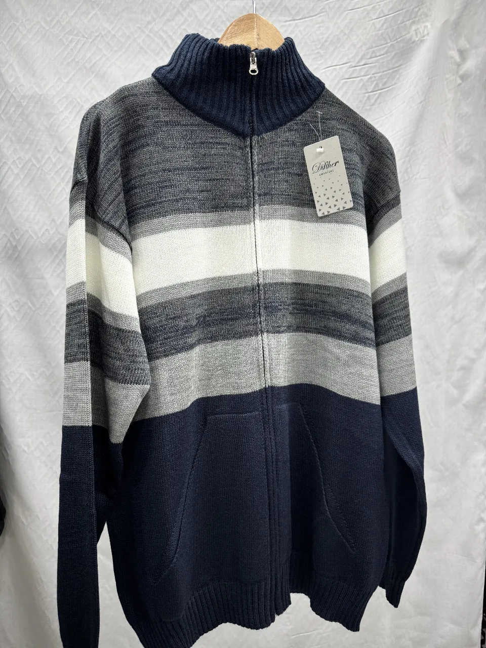 Sweater de hombre con cierre y cuello alto. Diseño a rayas en tonos grises, blanco y azul marino. Ideal para el invierno.