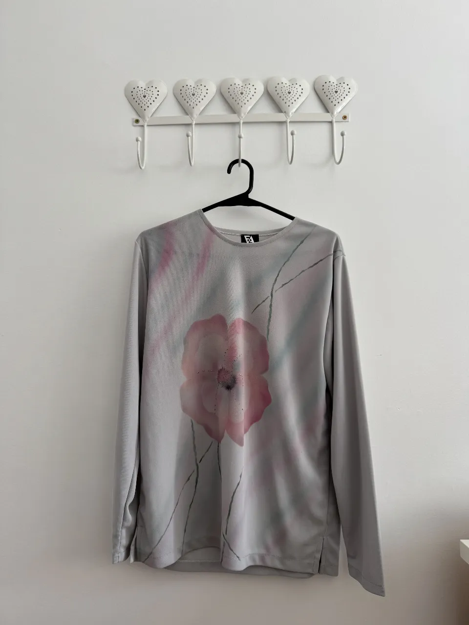 Remera manga larga gris con estampado floral en tonos rosas. Ideal para un look casual y cómodo.
