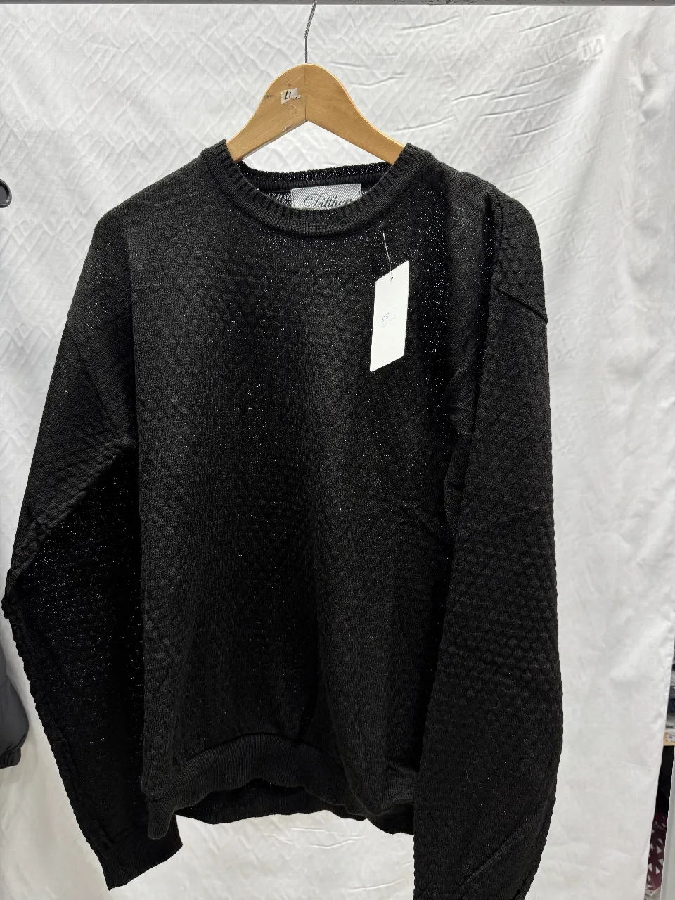 Sweater negro de tejido con diseño en relieve. Cuello redondo y mangas largas. Ideal para un look casual y abrigado.