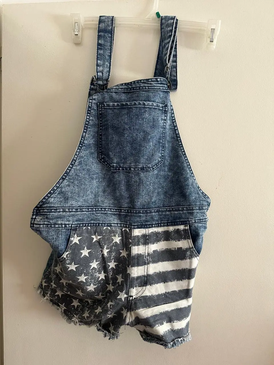 Enterito de jean con diseño de bandera americana. Talle 40, con detalles de desgaste y flecos en el borde inferior. Ideal para un look casual y patriótico. TALLE 40