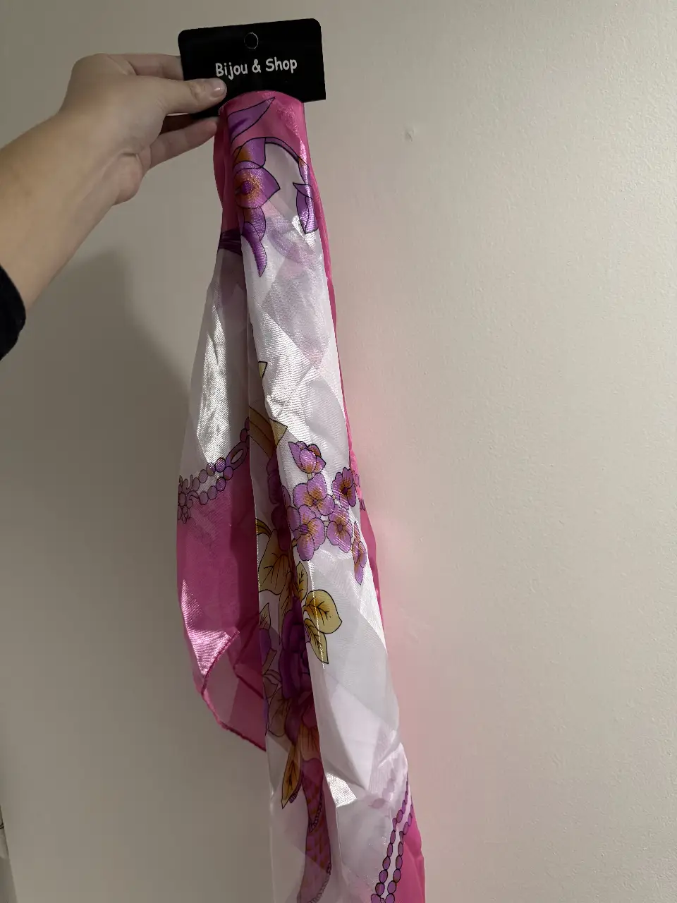 Pañuelo de seda rosa y blanco con estampado floral, ideal para complementar cualquier look femenino. Perfecto para un toque de elegancia y estilo.