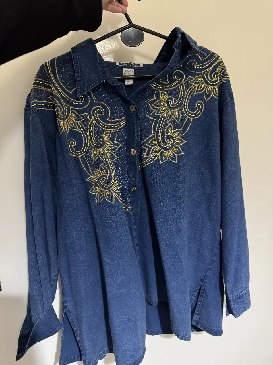 Camisa de jean azul con bordados dorados. Diseño con detalles florales y botones. Ideal para un look vintage. tiene una manchita en la parte de adelante. sin uso. Talle 1x