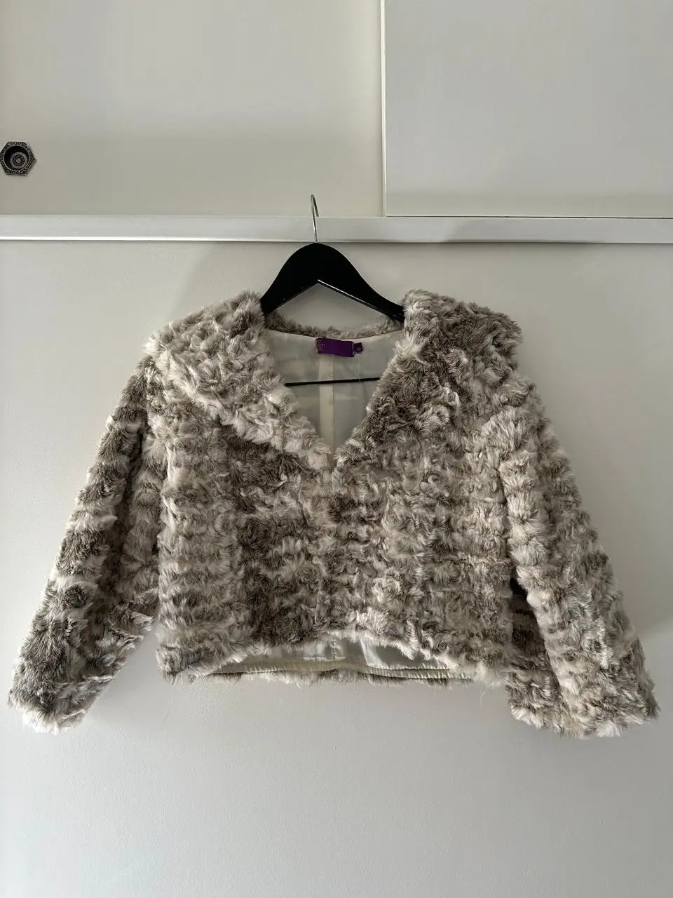 Campera de piel sintética con diseño de peluche en tonos grises y blancos. Ideal para un look abrigado y a la moda.