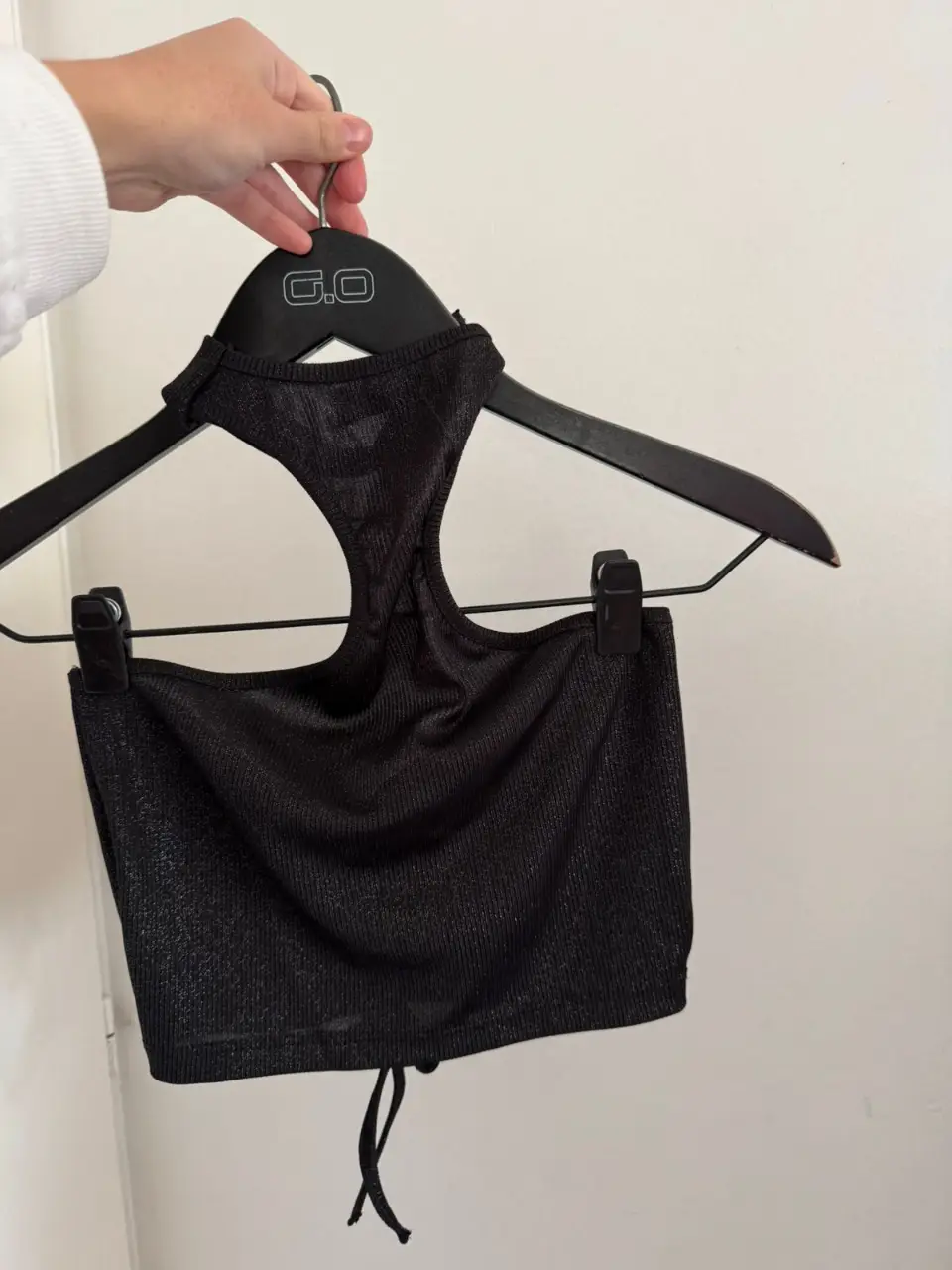 Top negro con cuello halter y detalle fruncido. Ideal para entrenamientos o looks casuales.