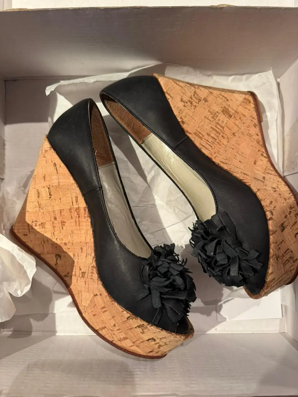 Sandalias de mujer con plataforma de corcho y detalle de flor en la punta. Ideales para un look elegante y moderno.