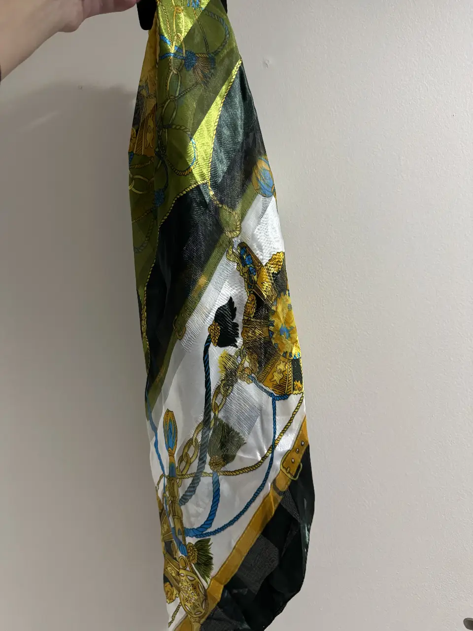 Pañuelo de seda con estampado barroco en tonos verdes, dorados, blancos y azules. Ideal para darle un toque de elegancia a cualquier look.