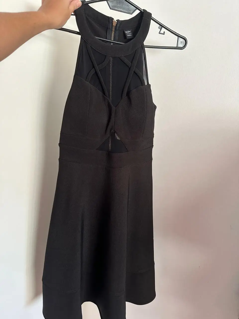 Vestido negro corto con detalles cut-out y cierre en la espalda. Ideal para una salida nocturna o evento formal.